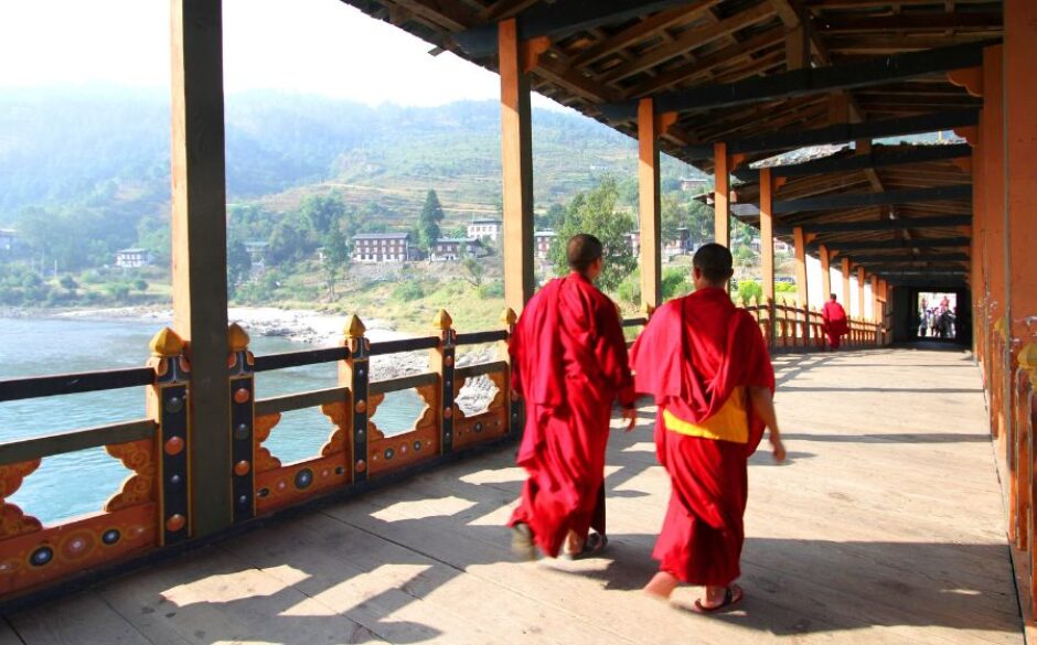 Customs and traditions in Bhutan - Two young monks walking on PUNA MOCCHU BAZAM Punakha Dzong Monastery or Pungthang Dewachen Phodrang Bhutan